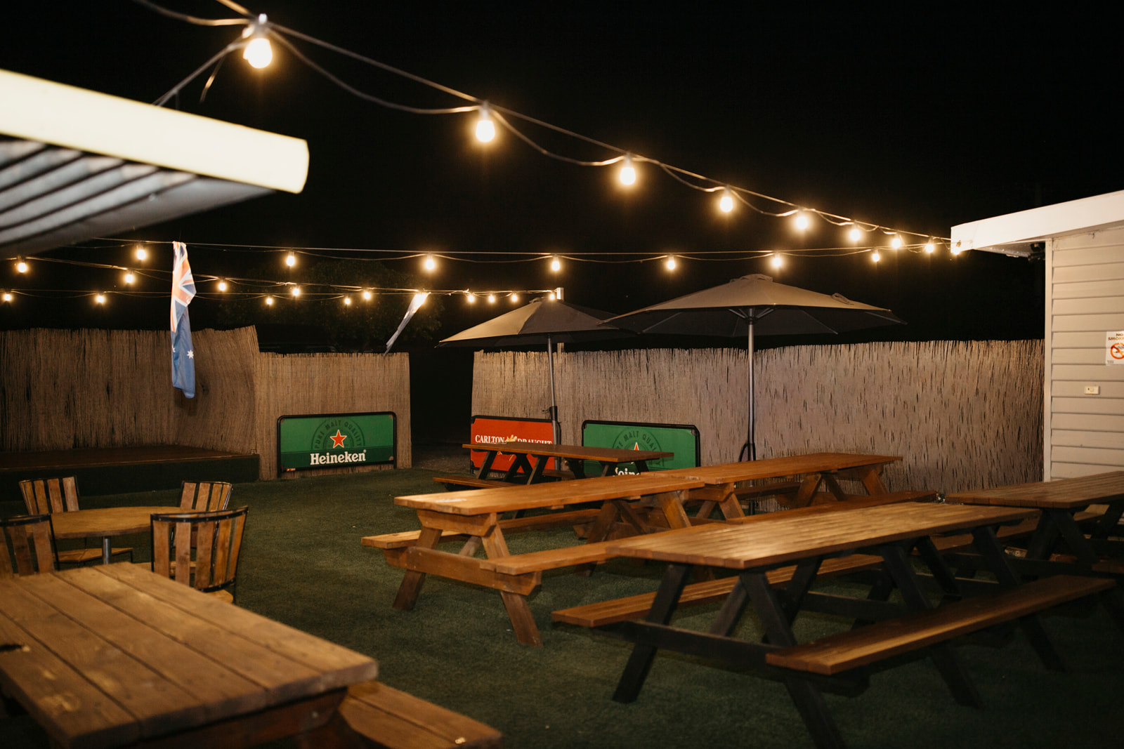 The beer garden at night under warm festoon lights